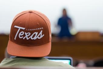 Photo of a college student wearing a UT Austin ball cap